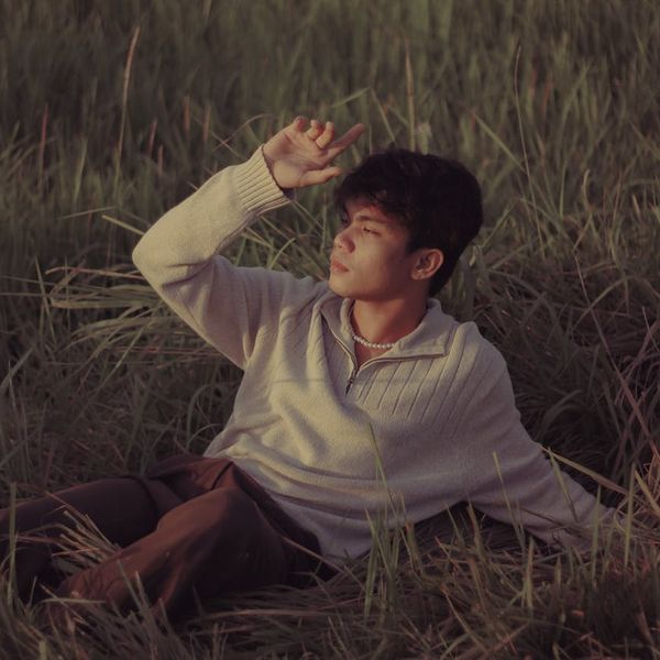 Person meditating peacefully outdoors during a sunset with calm surroundings.